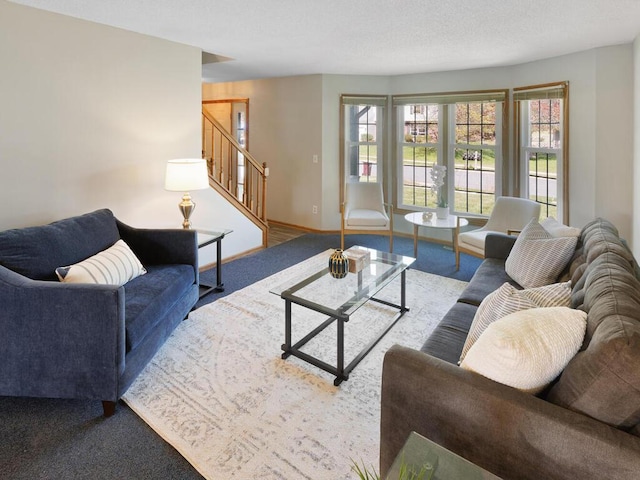 carpeted living area with stairway and baseboards