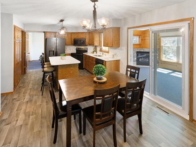 dining room featuring light wood-style floors, a chandelier, baseboards, and vaulted ceiling