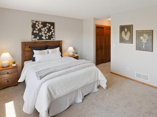 carpeted bedroom with a closet and baseboards