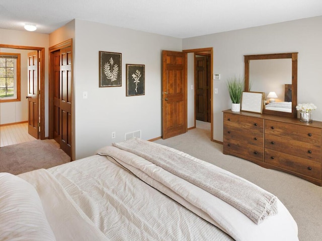 carpeted bedroom with baseboards and a closet