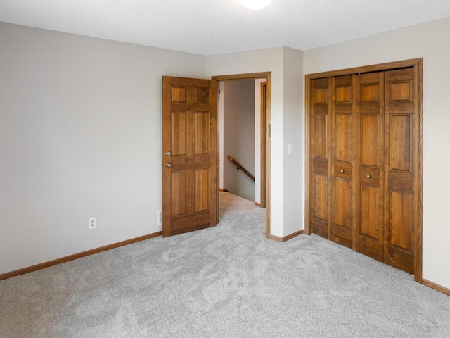 unfurnished bedroom with carpet, baseboards, and a closet