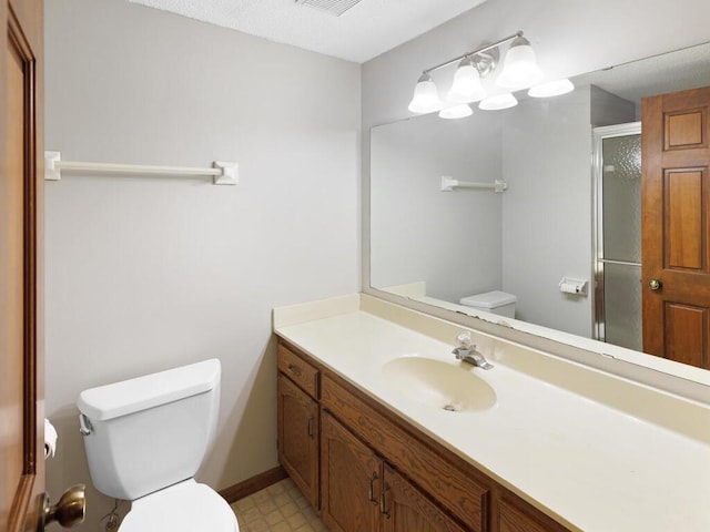 bathroom with toilet, tile patterned floors, a stall shower, and vanity