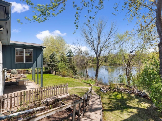 view of grassy yard featuring a water view and a patio