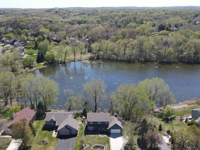 aerial view of property's location with a nearby body of water and a forest