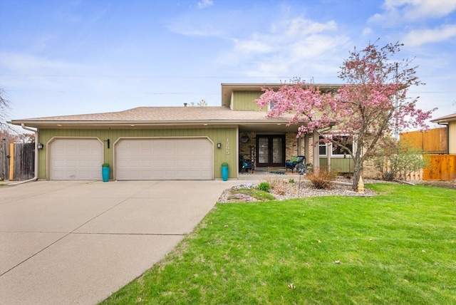 view of front of house with a garage, fence, driveway, and a front yard