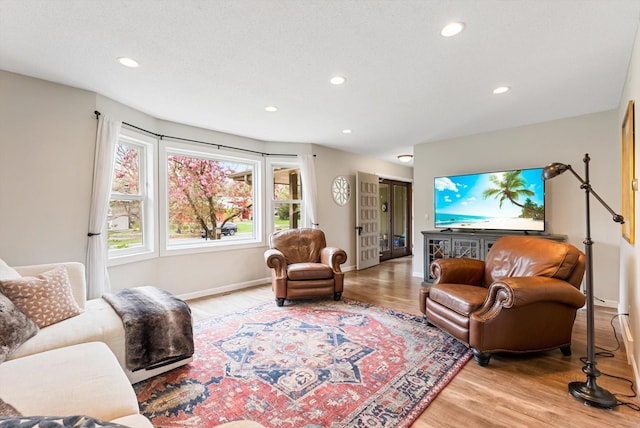 living area with light wood-type flooring, recessed lighting, and baseboards