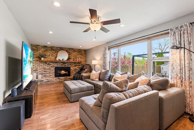 living room featuring recessed lighting, light wood finished floors, ceiling fan, and a fireplace
