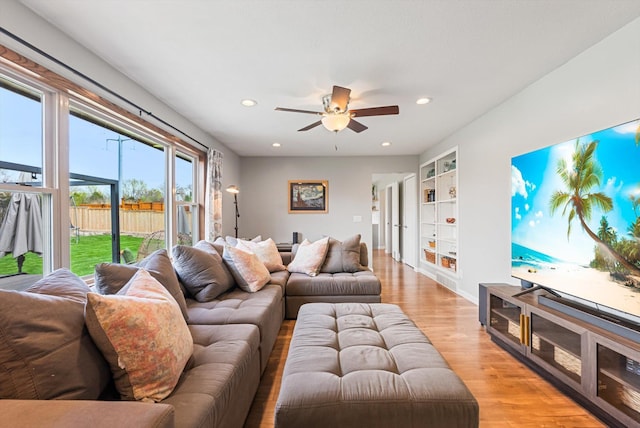 living room with recessed lighting, ceiling fan, built in features, and light wood finished floors