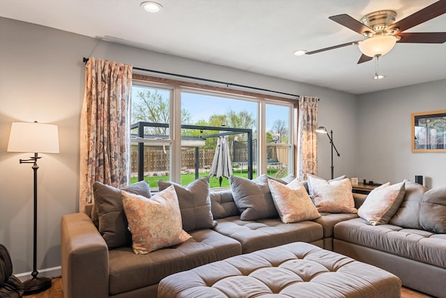living area with recessed lighting, ceiling fan, a wealth of natural light, and wood finished floors