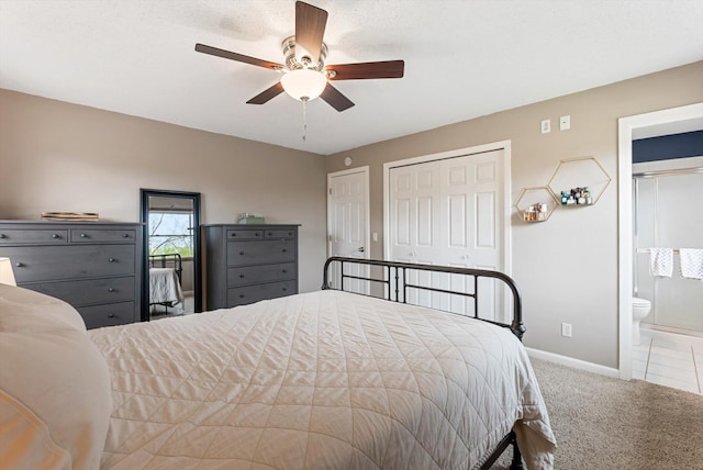carpeted bedroom featuring baseboards, ensuite bathroom, and a ceiling fan