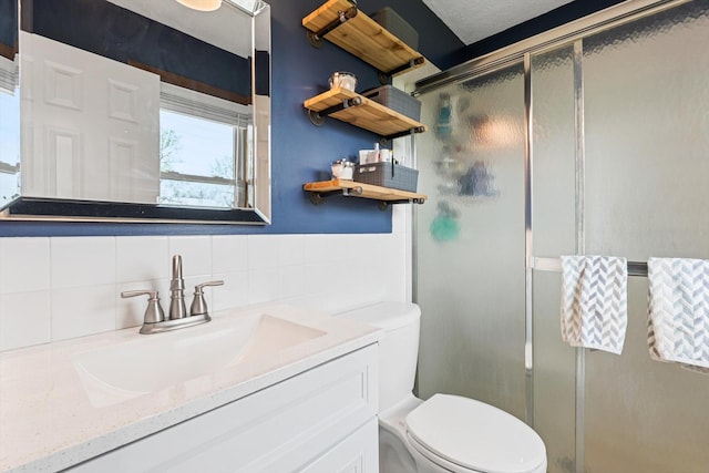 bathroom featuring vanity, toilet, and a stall shower