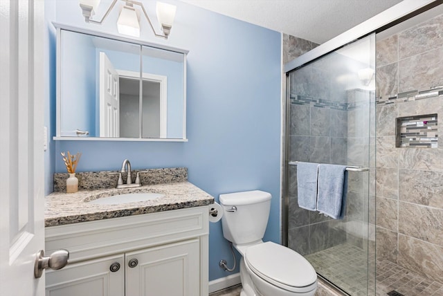 full bathroom with toilet, a shower stall, and vanity
