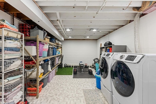 washroom featuring concrete block wall and independent washer and dryer