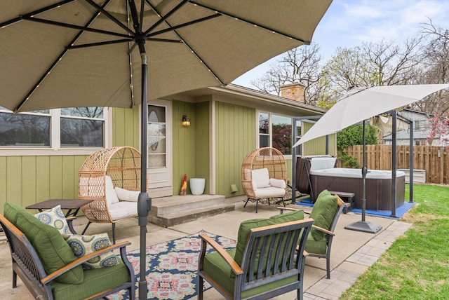 view of patio / terrace featuring fence, an outdoor living space, and a hot tub