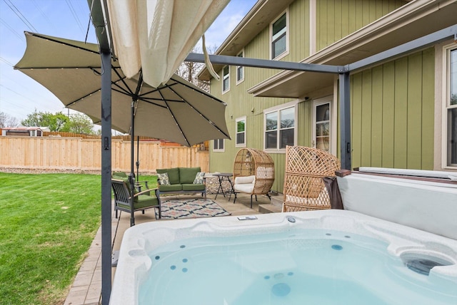 view of patio / terrace featuring a hot tub, fence, and an outdoor hangout area