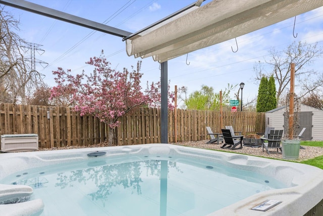 view of swimming pool featuring an outdoor structure, an outdoor fire pit, fence, and a storage shed