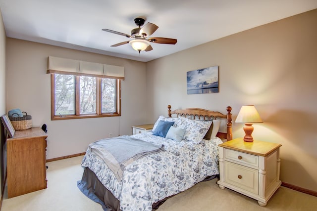 bedroom with a ceiling fan, baseboards, and light carpet