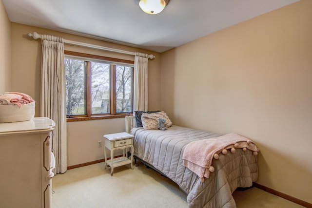 bedroom featuring baseboards and light carpet