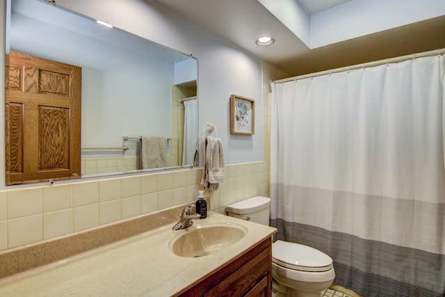 bathroom featuring recessed lighting, vanity, toilet, and tile walls