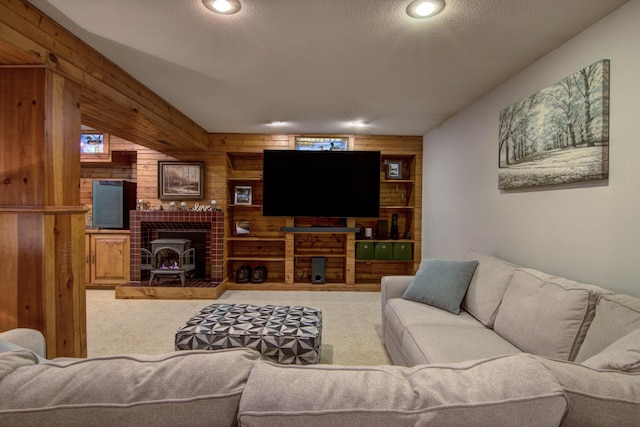 carpeted living area featuring wooden walls, recessed lighting, a textured ceiling, and a fireplace