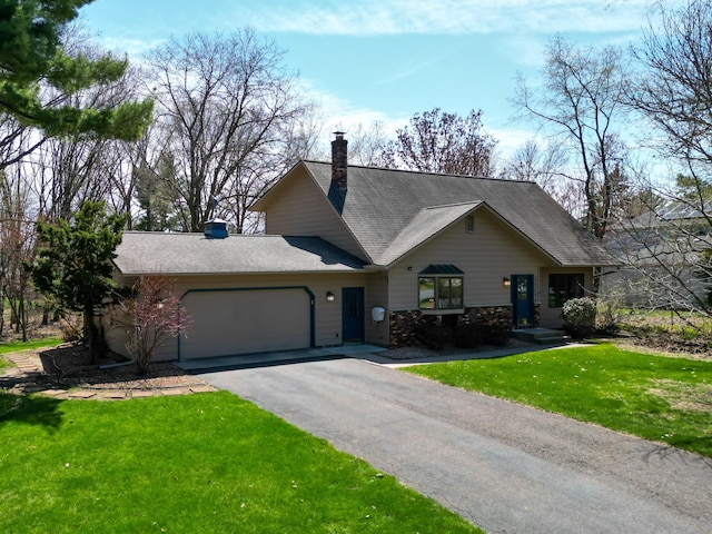 view of front of house featuring an attached garage, a chimney, a front lawn, and aphalt driveway