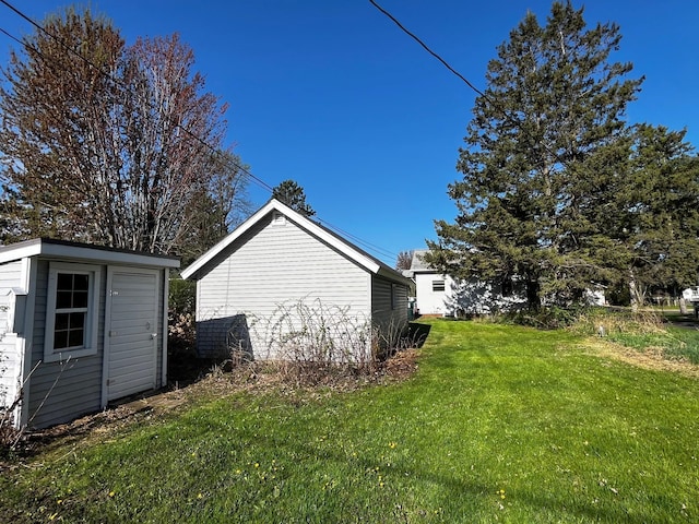 view of grassy yard featuring an outbuilding and a shed