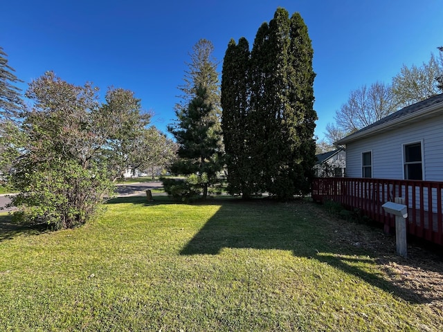 view of grassy yard with a wooden deck