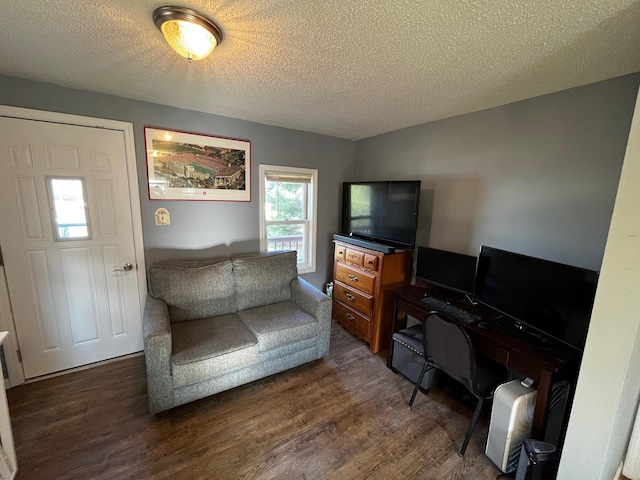 living room with dark wood finished floors, a textured ceiling, and an office area