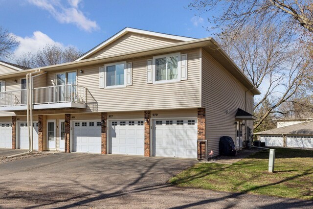 view of front of property with an attached garage, driveway, and a balcony