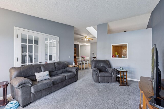 living area featuring baseboards, ceiling fan, a textured ceiling, french doors, and carpet