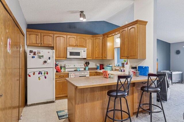 kitchen featuring a peninsula, white appliances, a textured ceiling, and lofted ceiling