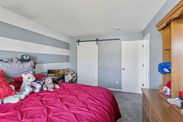 bedroom featuring carpet floors, a barn door, and a textured ceiling