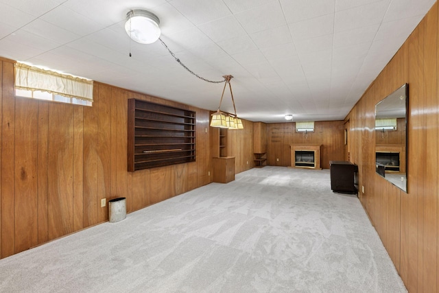 6309 Halifax Dr, Brooklyn Center, MN 55429 - basement featuring wooden walls, a glass covered fireplace, and carpet