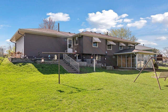 6309 Halifax Dr, Brooklyn Center, MN 55429 - rear view of house featuring a sunroom, central AC unit, and a yard