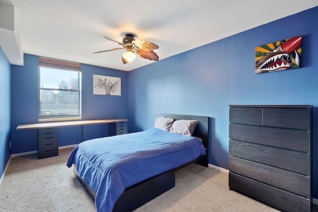 carpeted bedroom with baseboards, a textured ceiling, and ceiling fan