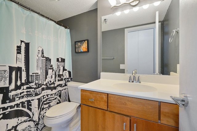 full bathroom featuring vanity, a textured ceiling, and toilet