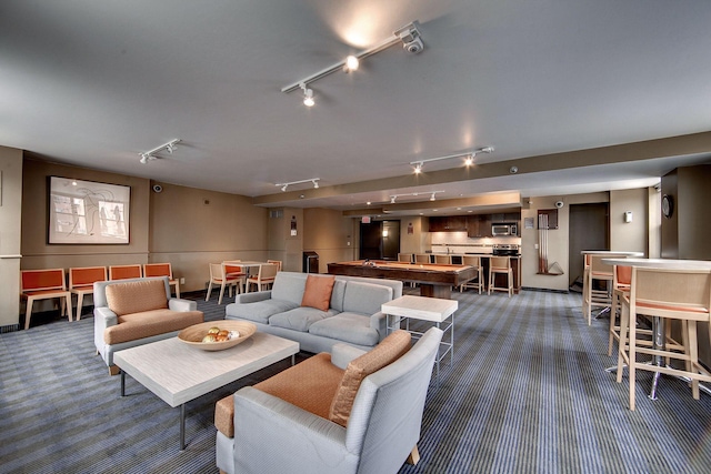 living room with rail lighting and dark carpet