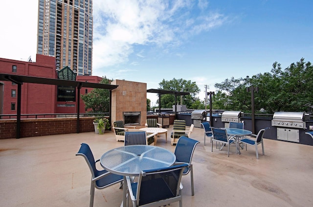 view of patio with area for grilling, exterior kitchen, exterior fireplace, and outdoor dining space