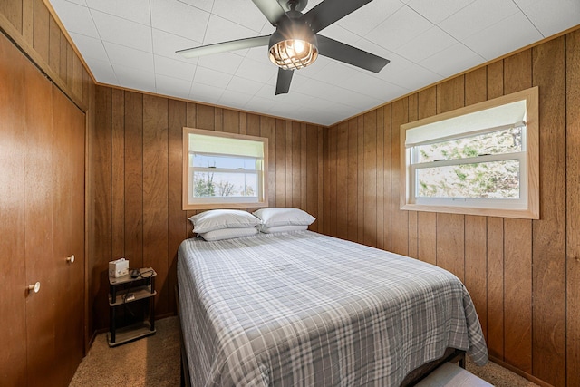 23920 Camp Dr, Daniels Twp, WI 54872 - bedroom with carpet flooring, wooden walls, a closet, and a ceiling fan