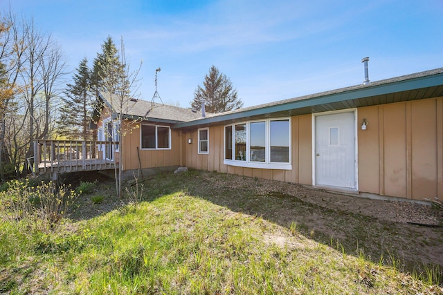 23920 Camp Dr, Daniels Twp, WI 54872 - rear view of house with board and batten siding and a wooden deck