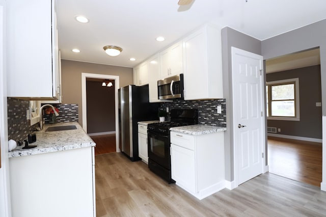 10424 Washburn Ave S, Bloomington, MN 55431 - kitchen featuring stainless steel appliances, a sink, tasteful backsplash, white cabinetry, and light wood-type flooring