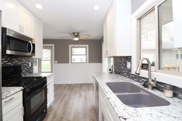 10424 Washburn Ave S, Bloomington, MN 55431 - kitchen featuring appliances with stainless steel finishes, a sink, white cabinets, decorative backsplash, and recessed lighting