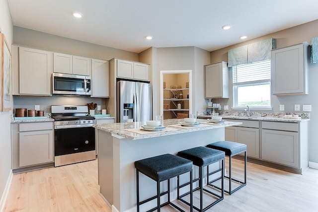 kitchen featuring light wood-type flooring, a breakfast bar area, a kitchen island, and stainless steel appliances