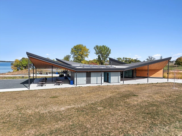 view of front of home featuring a patio, a water view, and a front yard
