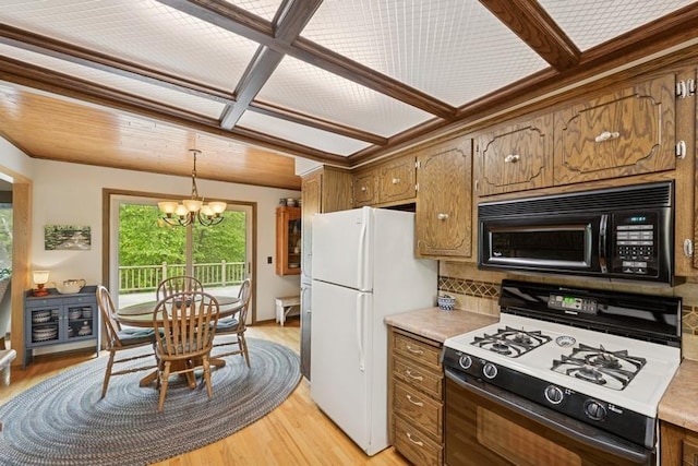 16523 243rd Ave NW, Orrock Twp, MN 55309 - kitchen with black microwave, range with gas stovetop, a chandelier, and light wood-style floors
