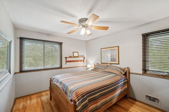 16523 243rd Ave NW, Orrock Twp, MN 55309 - bedroom with wood finished floors, a ceiling fan, a textured ceiling, and baseboards