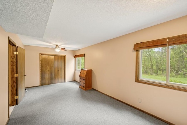 16523 243rd Ave NW, Orrock Twp, MN 55309 - unfurnished bedroom with a textured ceiling, a closet, ceiling fan, baseboards, and carpet floors