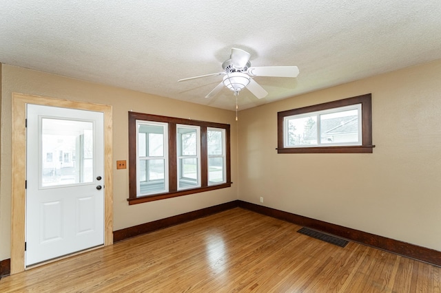 unfurnished room featuring baseboards, visible vents, ceiling fan, and light wood-type flooring