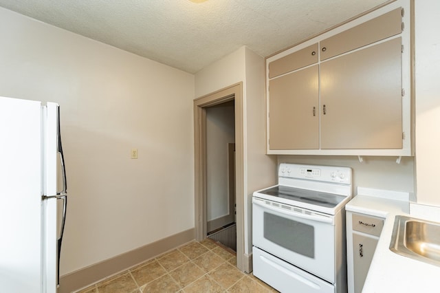 kitchen featuring a sink, white appliances, light countertops, a textured ceiling, and baseboards