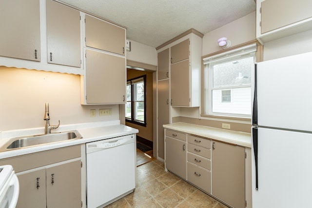 kitchen with a sink, light countertops, plenty of natural light, and white appliances
